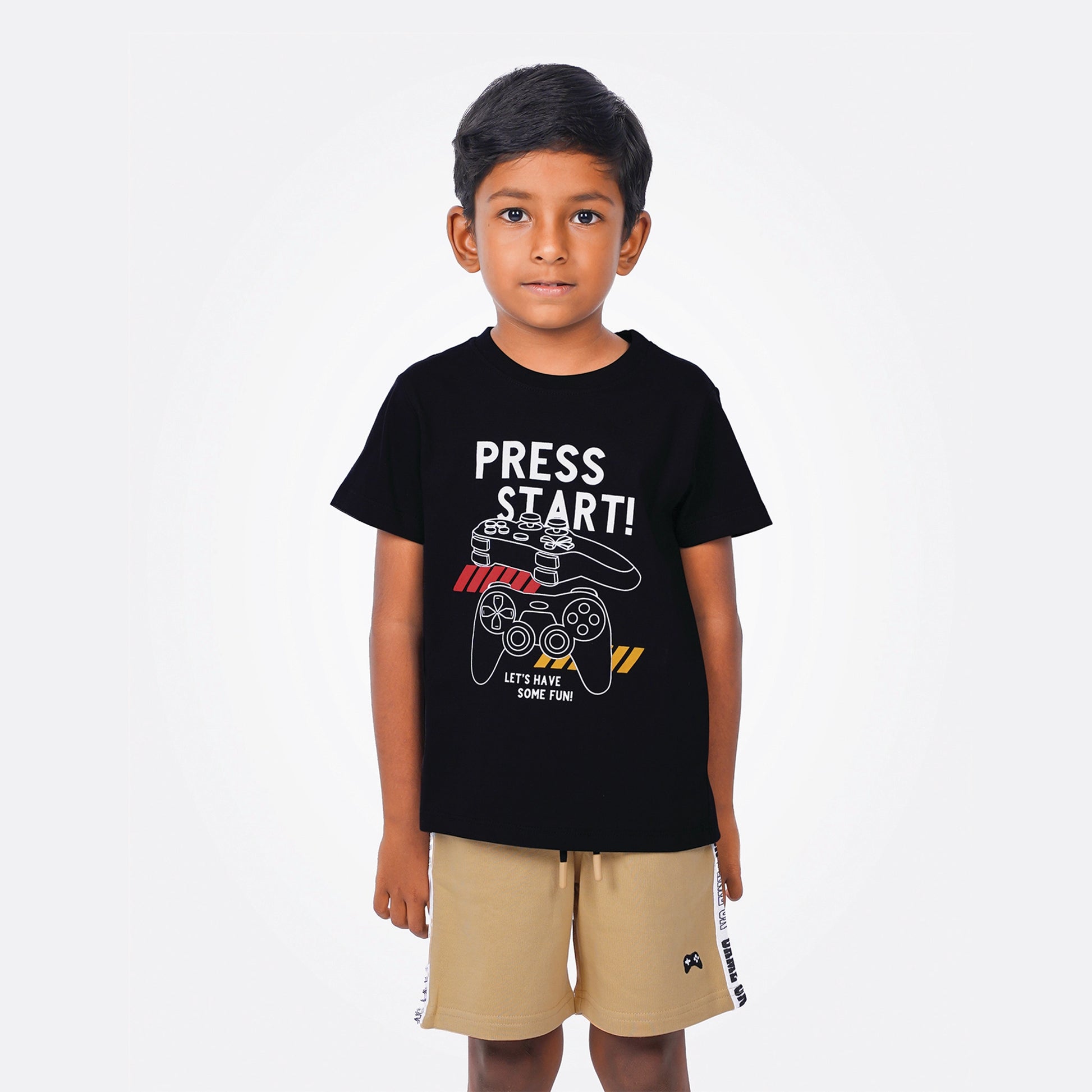 Child wearing a black t-shirt with 'Press Start!' design on a white background