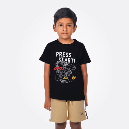 Child wearing a black t-shirt with 'Press Start!' design on a white background
